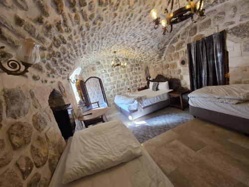 a bedroom with two beds in a stone building at Babussor konağı hotel in Eskiömerler