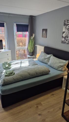 a large bed in a bedroom with a window at Stadtnah an der Förde 116 in Flensburg