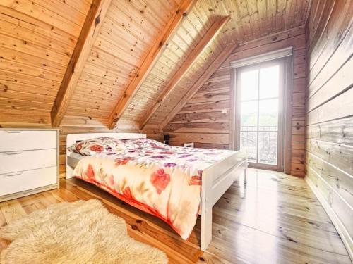 a bedroom with a bed in a wooden house at Domek z bali in Jarnołtówek