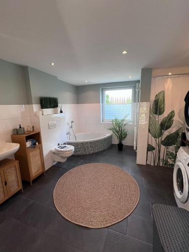 a bathroom with a tub and a toilet and a sink at Güden Pearl Bhaven Deck 6 ,Exklusive große Wohnung,Hochwertige Ausstattung,Privatparkplatz & Carport,Großer Garten mit Gartenhaus,Langzeitaufenthalt in Bremerhaven