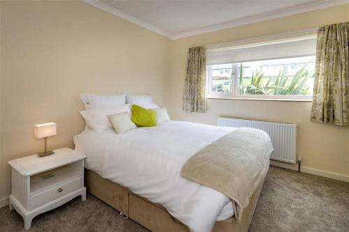 a bedroom with a large white bed with a window at 2 Bed in Pwllheli oc-45caed in Abersoch