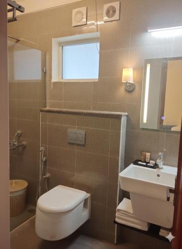 a bathroom with a toilet and a sink and a mirror at AR Residency Tnagar Chennai in Chennai