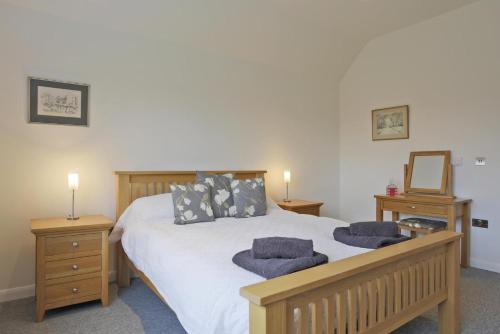 a bedroom with a bed with two night stands and a mirror at 2 Bed in Leiston oc-cqa in Theberton
