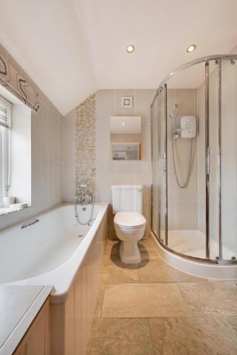 a bathroom with a shower and a toilet and a tub at 3 Bed in Bodham oc-1638 in Bodham