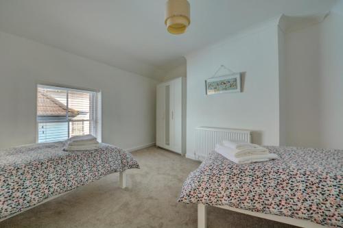 a white room with two beds and a window at 3 Bed in Cromer oc-1727 in Cromer
