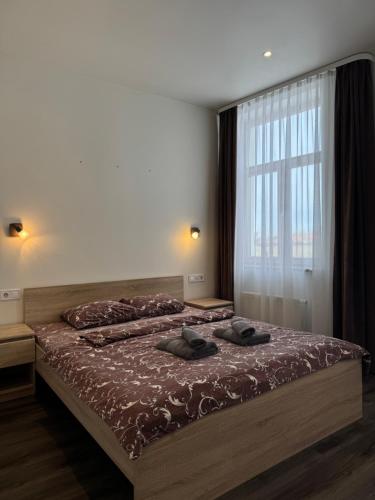 una camera da letto con due letti e una grande finestra di Marbella Rezidence a Ventspils