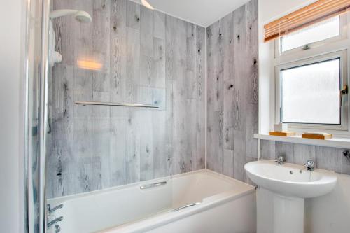 a bathroom with a white tub and a sink at 3 Bed in Abersoch oc-kook72 in Abersoch