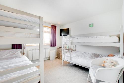 a bedroom with two bunk beds and a chair at 3 Bed in Abersoch oc-kook72 in Abersoch
