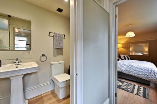 a bathroom with a sink and a toilet and a bed at Finest Retreats - St Germains Annexe in Sandwich