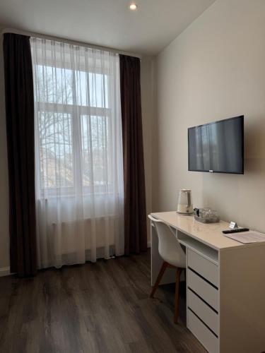 una camera d'albergo con una scrivania e una finestra di Marbella Rezidence a Ventspils