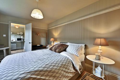 a bedroom with a bed and a table and lamps at Finest Retreats - St Germains Annexe in Sandwich
