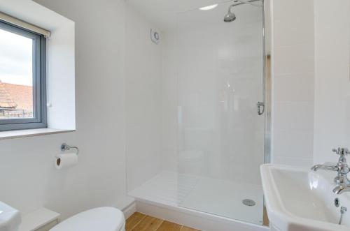 a white bathroom with a shower and a sink at 3 Bed in Shereford oc-2173 in Tatterford