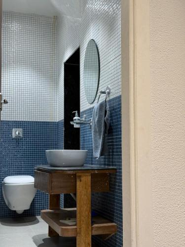 a bathroom with a sink and a toilet and a mirror at Zoe Cozy Escape with Big Projector in Amritsar