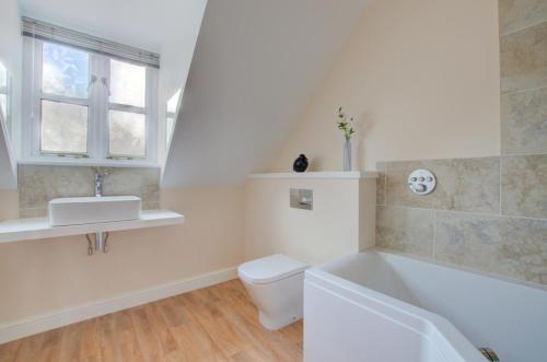 a white bathroom with a toilet and a sink at 2 Bed in Blakeney oc-1558 in Blakeney