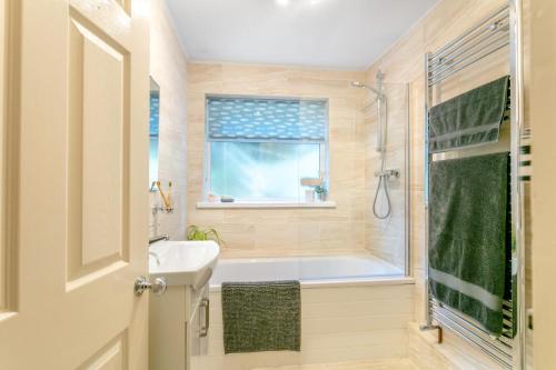 a bathroom with a tub and a sink and a shower at 2 Bed in Appledore oc-drum in Appledore