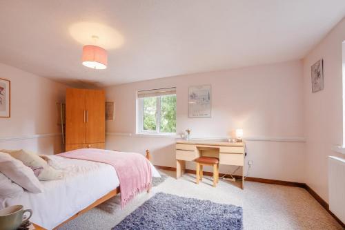 a bedroom with a bed and a desk and a window at 2 Bed in Swimbridge oc-n0209 in Swimbridge