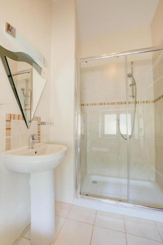 a white bathroom with a shower and a sink at 1 Bed in Tiverton oc-gear in Bampton