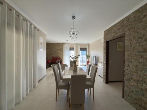 a dining room with a table and chairs at Terracos Da Meia Praia in Meia Praia
