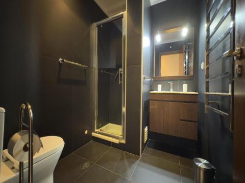 a bathroom with a toilet and a glass shower at Terracos Da Meia Praia in Meia Praia