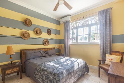 a bedroom with a bed and a chair and a window at Los Balcones, Sosua, Ocean Front! in Sosúa