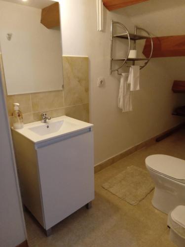 a bathroom with a white sink and a toilet at Piso Adrian in Sierra de Outes