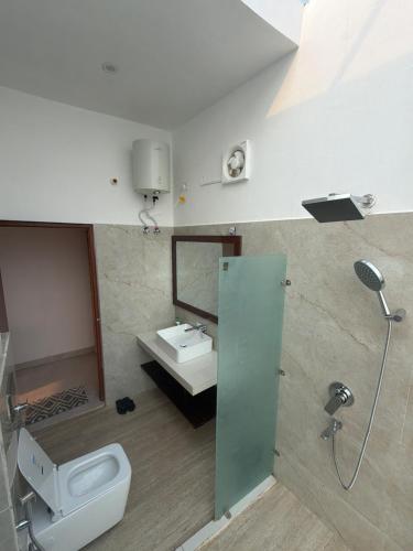 a bathroom with a toilet and a sink and a shower at The Tarai Pilibhit in Kālīnagar