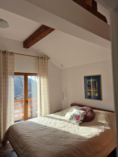 ein Schlafzimmer mit einem Bett und einem großen Fenster in der Unterkunft Serbina in Kandalica