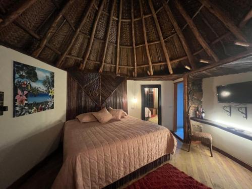 ein Schlafzimmer mit einem Bett in einem Raum mit einer Decke in der Unterkunft Tawaca SANCTUARY in Calabazo