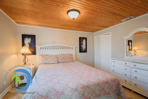 a bedroom with a bed and a wooden ceiling at Cg Beach Bungalow #1 in Myrtle Beach