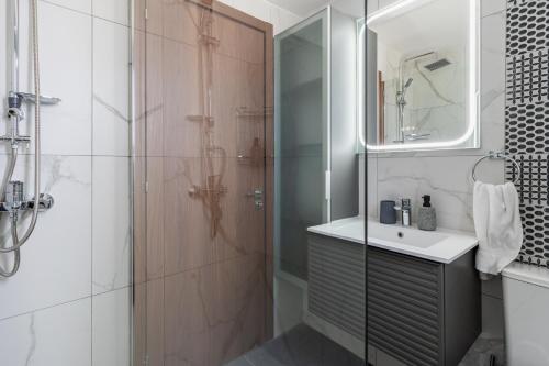 a bathroom with a shower and a sink and a mirror at Hinoki 2-Bedroom Apartment in Larnaca