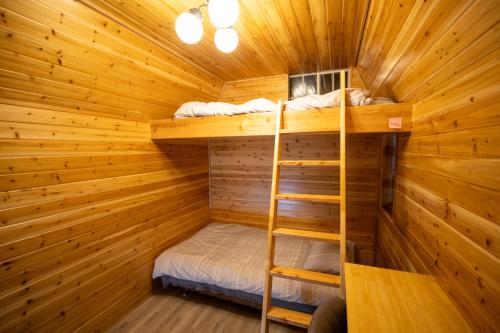 a room with two bunk beds in a log cabin at Lodge Crea in Ujimi