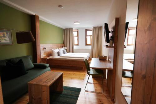 a hotel room with a bed and a couch at Gasthaus Grüner Baum in Prichsenstadt