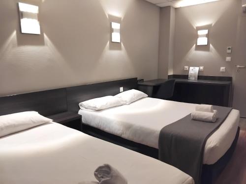 a hotel room with two beds with towels on them at Hôtel Le Bratoria, anciennement Le Saint Vincent in Vourles