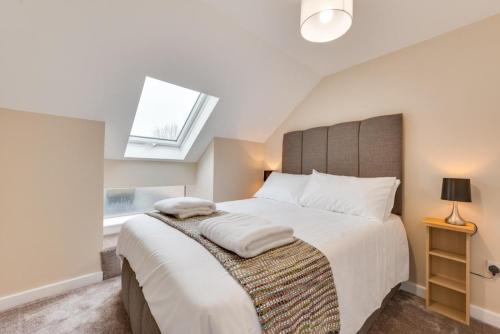 a bedroom with a large bed with a skylight at 6 Bed in Great Waldingfield oc-ac4 in Waldingfield