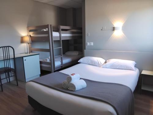 two beds in a room with two bunk beds at Hôtel Le Bratoria, anciennement Le Saint Vincent in Vourles
