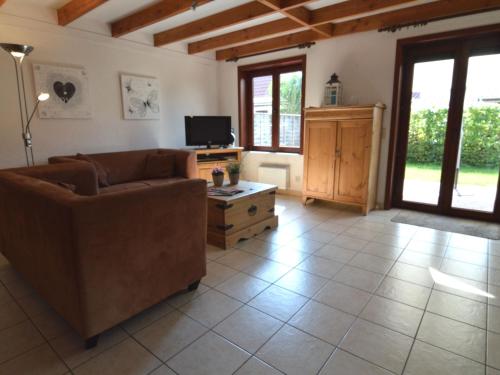 a living room with a couch and a tv at Cosy fisherman s house ideally located for coastal walking and cycling tours in De Haan