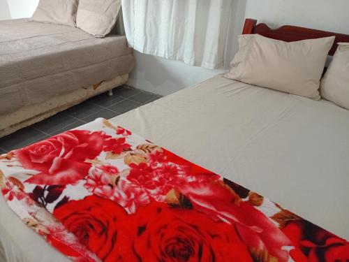 a bed with a red and white blanket on it at DOUBLE e RETIRO das PRINCESAS aluguel de quartos in Salinópolis