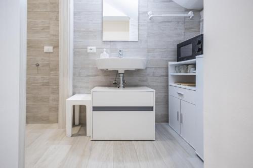 a white bathroom with a sink and a counter at MAGGIORE Affittacamere in Ravenna