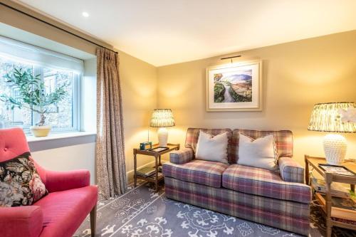 a living room with a couch and a chair at 1 Bed in Brassington oc-dcneb in Brassington