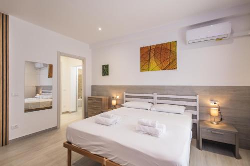 a bedroom with a large white bed with two pillows at MAGGIORE Affittacamere in Ravenna