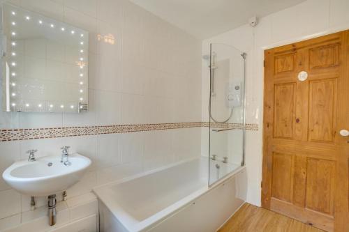 a bathroom with a tub and a sink and a shower at 2 Bed in Matlock oc-dcocc in Two Dales