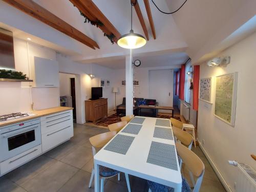 a kitchen with a white table and some chairs at Roland Apartamenty in Świeradów-Zdrój
