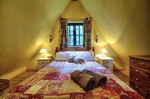 ein Schlafzimmer mit einem großen Bett im Dachgeschoss in der Unterkunft Alde Barn in Stonham Aspall