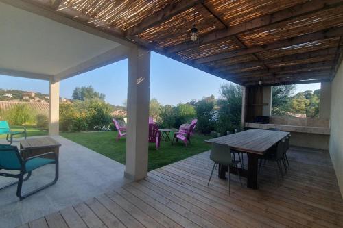 a patio with a table and chairs on a deck at CASA VIGNA - villa T4 piscine privée in Sainte-Lucie de Porto-Vecchio