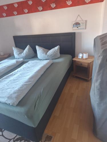 ein Schlafzimmer mit einem Bett mit blauen Laken und Kissen in der Unterkunft Piacere Emden in Emden