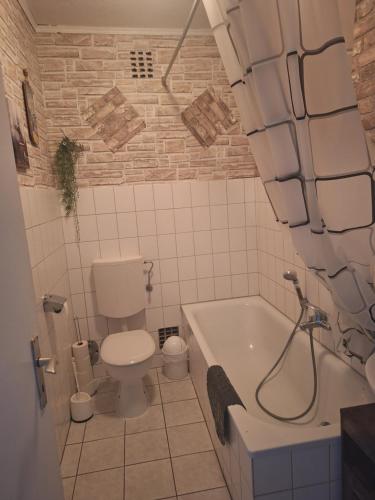 ein Badezimmer mit Toilette und Badewanne in der Unterkunft Piacere Emden in Emden