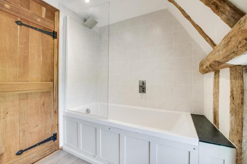 a bathroom with a white tub and white tiles at 5 Bed in Finningham oc-obhf in Finningham