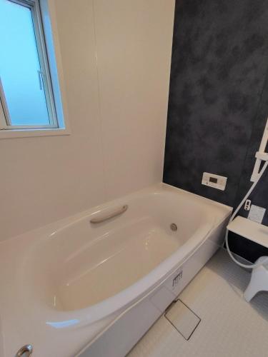 a white bath tub in a bathroom with a window at Seaside House Cozy - Vacation STAY 03320v in Sanmu