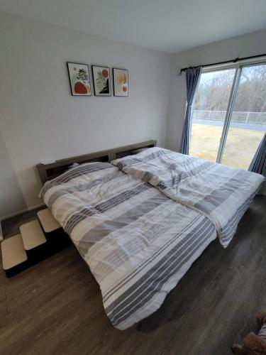 a bed in a bedroom with a large window at Seaside House Cozy - Vacation STAY 03320v in Sanmu