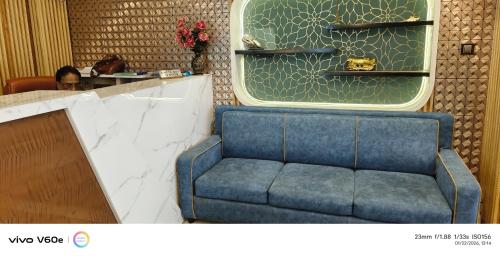 a blue couch sitting in front of a counter at D. K. INTERNATIONAL HOTEL PVT. LTD in Calcutta Bara Bazar